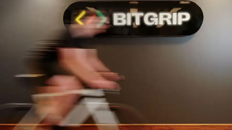 Im Büro von IT-Dienstleister und JobRad-Arbeitgeber BitGrip fährt ein Mitarbeiter vor dem Unternehmens-Logo mit leichter Bewegungsunschärfe.